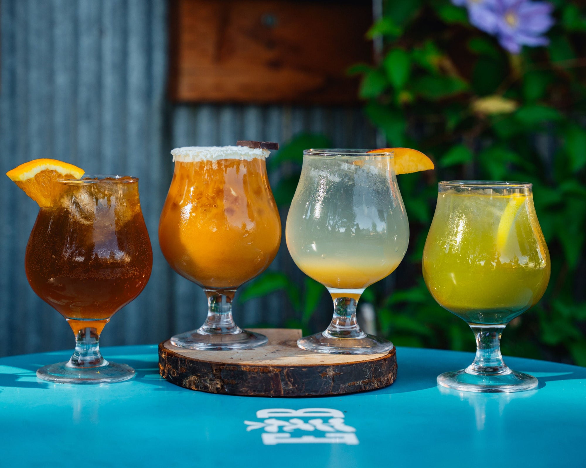 A flight of four fall seasonal drinks on a café table