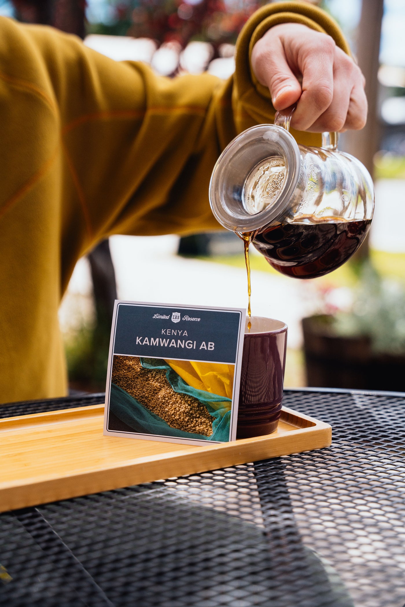 Pour-over coffee brewing beside a bag of Kenya Kamwangi AB